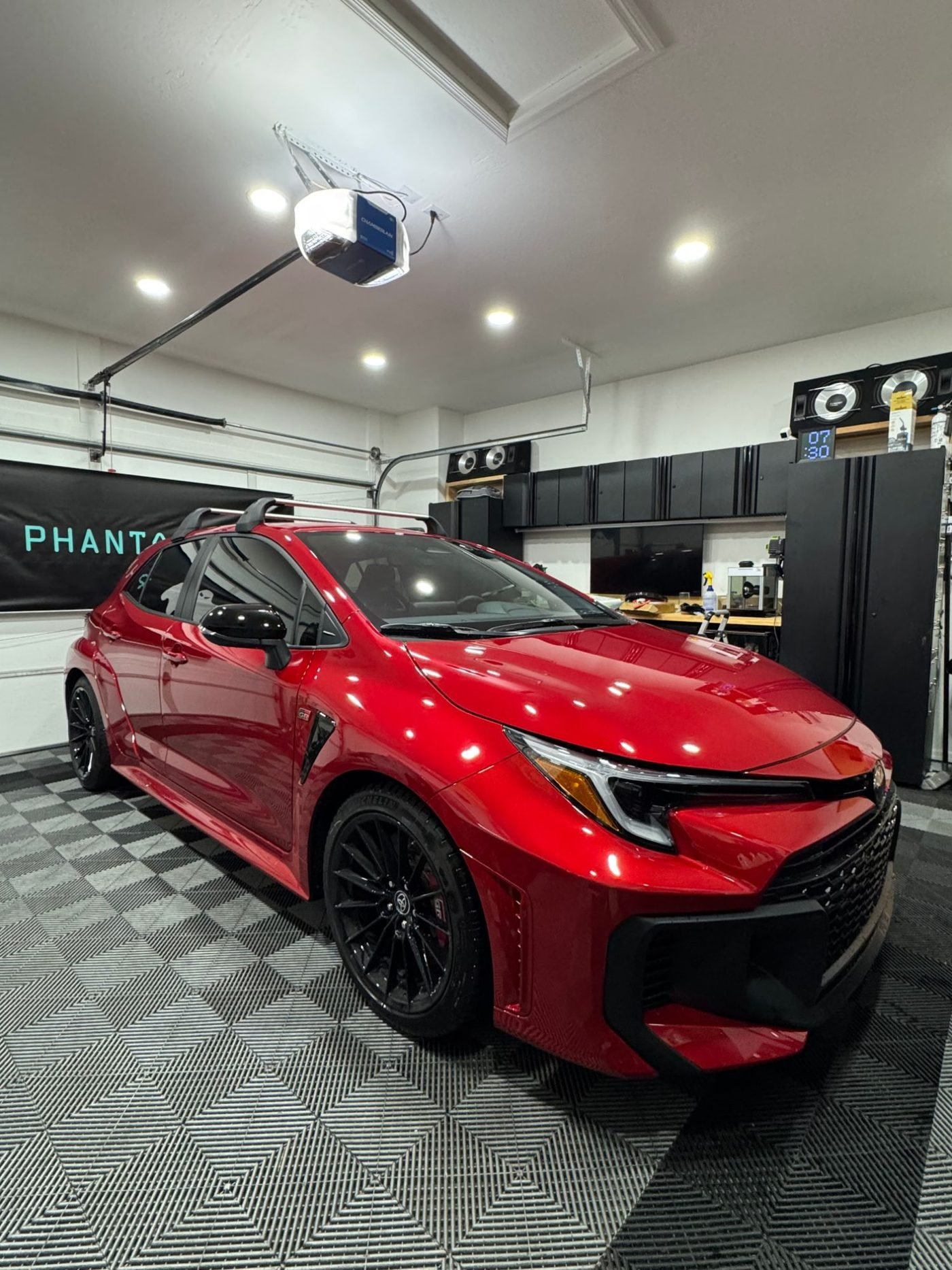 A red Toyota GR Corolla in John Le's home garage, the original Phantom Tint shop