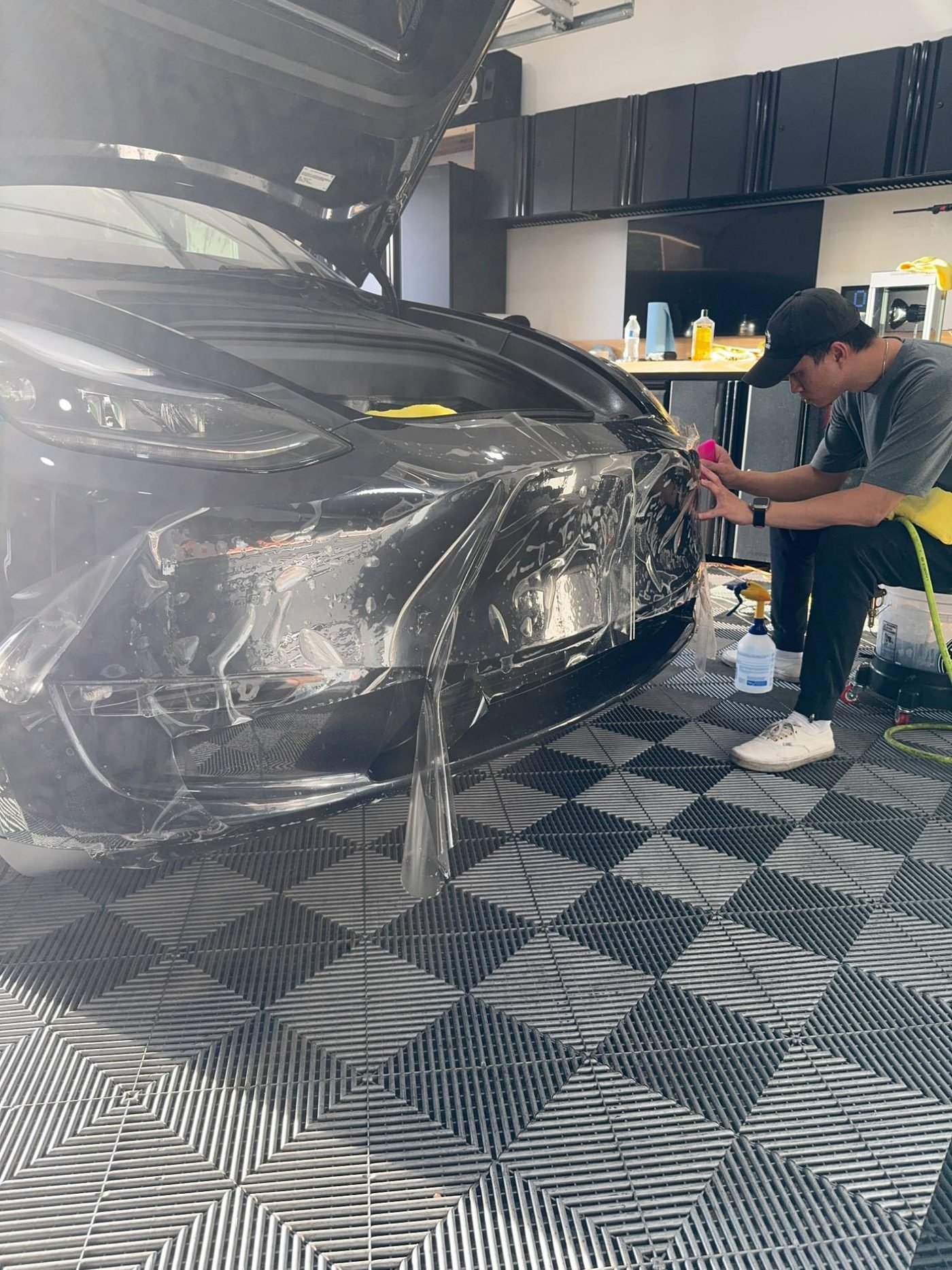 Paint protection film being installed on a friend's Tesla in a home garage